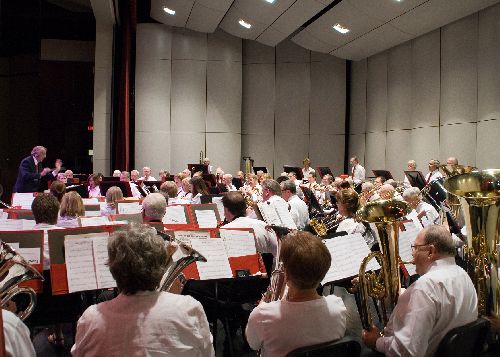 A group of musicians sits on a stage.