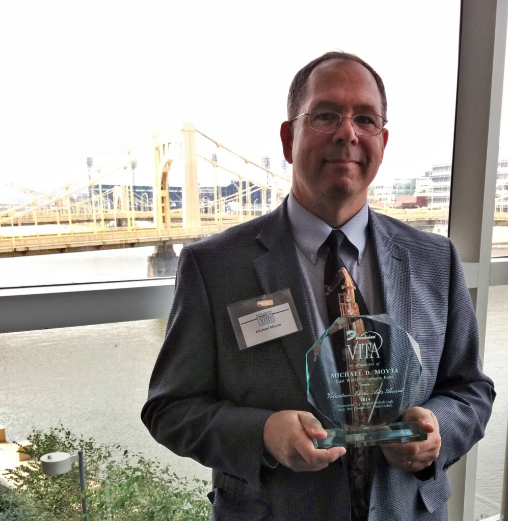 Mike Moyta with his VITA Award with a bridge in the background